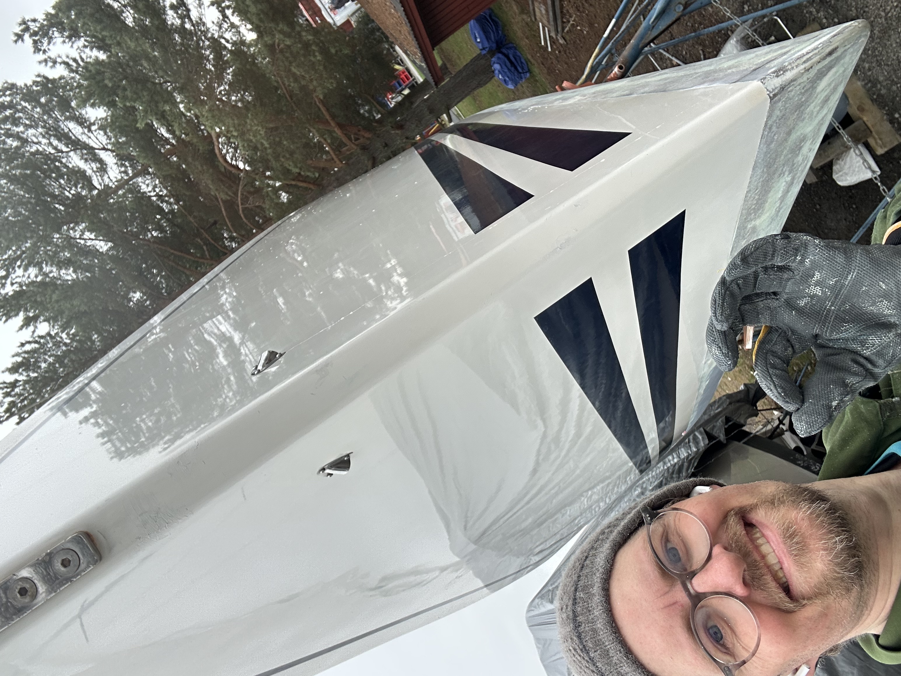 Marcus with the finished hull — polished topsides, keel painted, ready to go